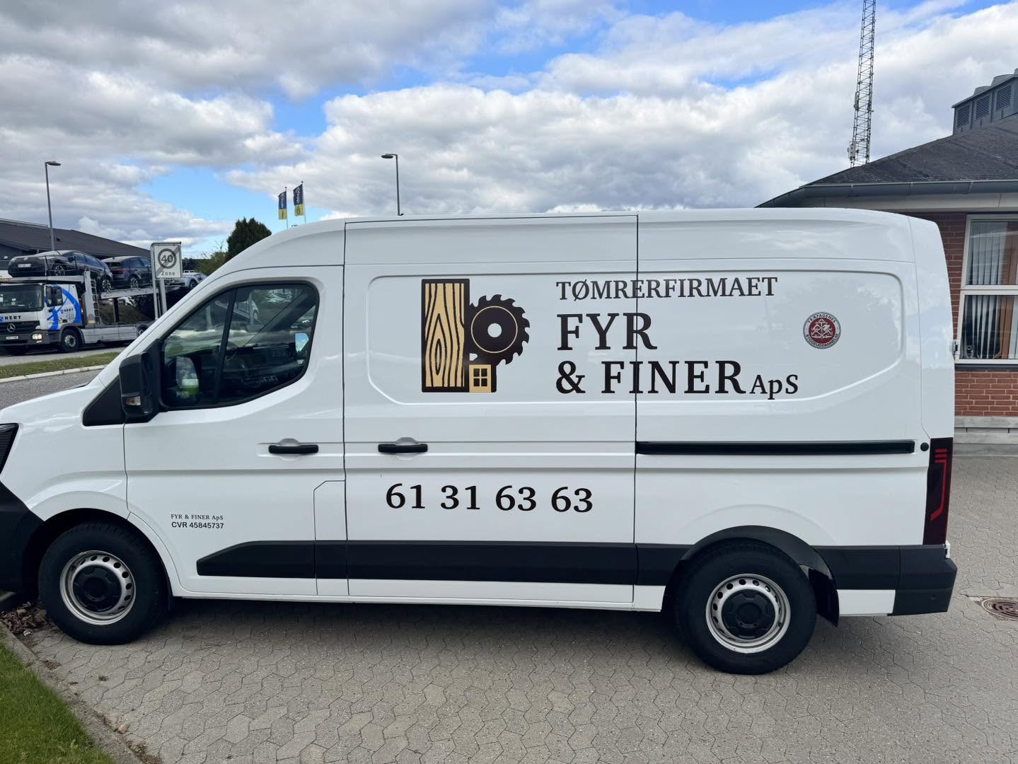 Firmabil med Fyr og Finérs logo på vej til opgave